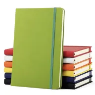 Toma fotográfica de libretas promocionales con cubierta flexible en color verde manzana y banda elástica de cierre, sobre una pila de cuadernos en colores variados para personalización empresarial.