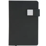 Toma fotográfica de libretas promocionales con cubierta rígida en color negro, broche magnético lateral con placa metálica cuadrada y sujetador para bolígrafo ideal para grabado de marca.